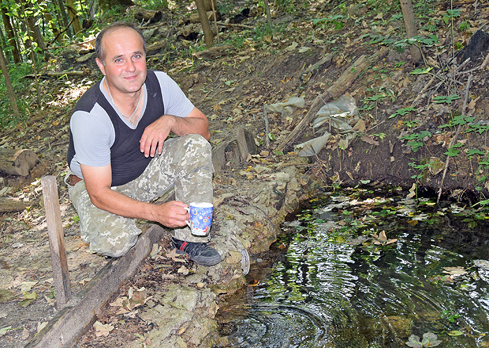 Інспектор з охорони природозаповідного фонду парку Олександр Іщук запрошує гарячої пори випити горнятко прохолодної водиці з джерела. Фото автора